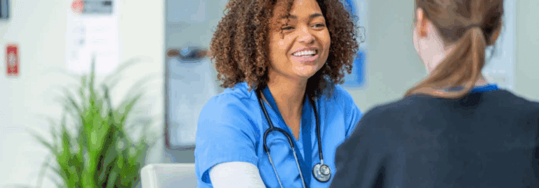 A mental health professional in scrubs smiling and engaging with a patient, representing the importance of compassionate care in mental health roles.