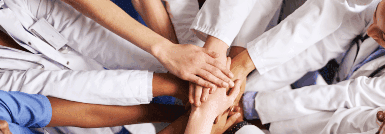 Mental Health professionals joining hands to represent multidisciplinary teamwork in mental health services.