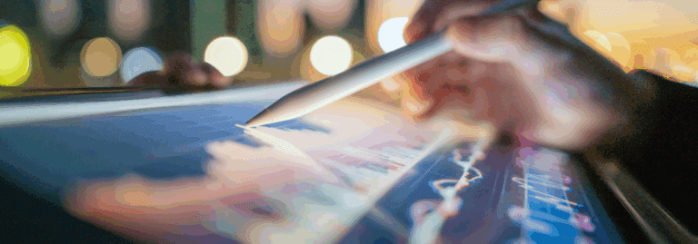 Close-up of a hand using a digital pen to analyse data on a tablet screen, symbolising data-driven workforce planning and strategic decision-making in mental health services.