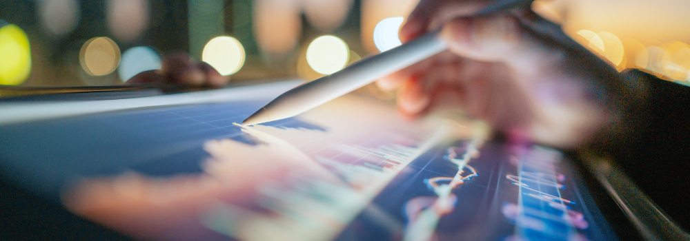 Close-up of a hand using a digital pen to analyse data on a tablet screen, symbolising data-driven workforce planning and strategic decision-making in mental health services.