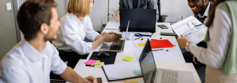 Mental health professionals in a team meeting discussing staffing, costs and workforce planning in an office setting.