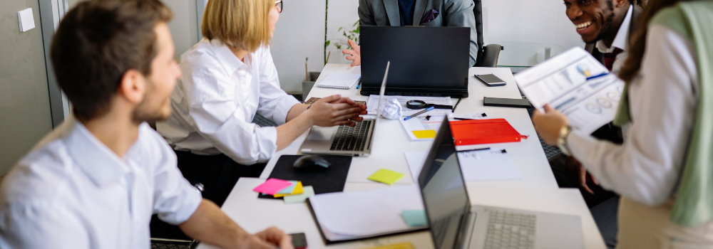 Mental health professionals in a team meeting discussing staffing, costs and workforce planning in an office setting.