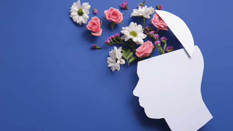 Illustration of a human head silhouette with flowers emerging from the mind, representing mental health awareness and emotional wellbeing.