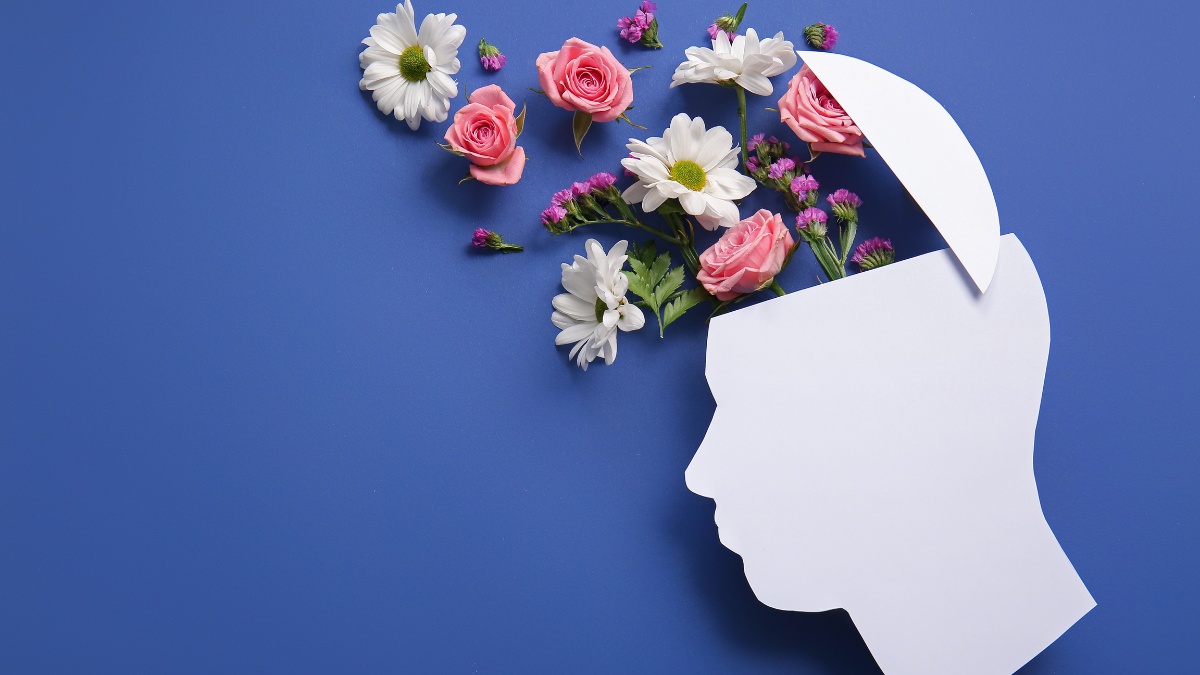 Illustration of a human head silhouette with flowers emerging from the mind, representing mental health awareness and emotional wellbeing.